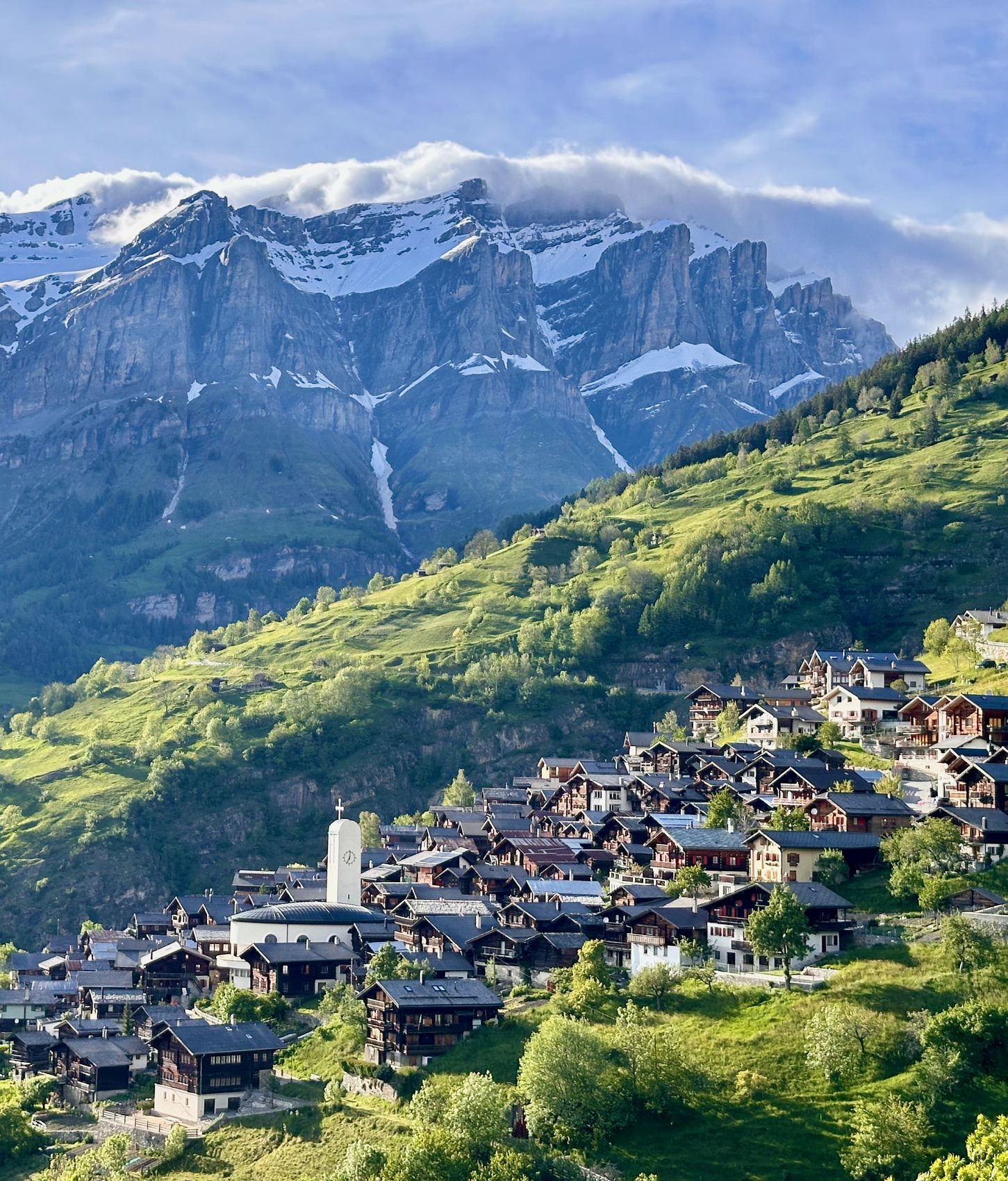 Albinen am Sonnenhang: das Dorf vor der Felswand im Morgenlicht